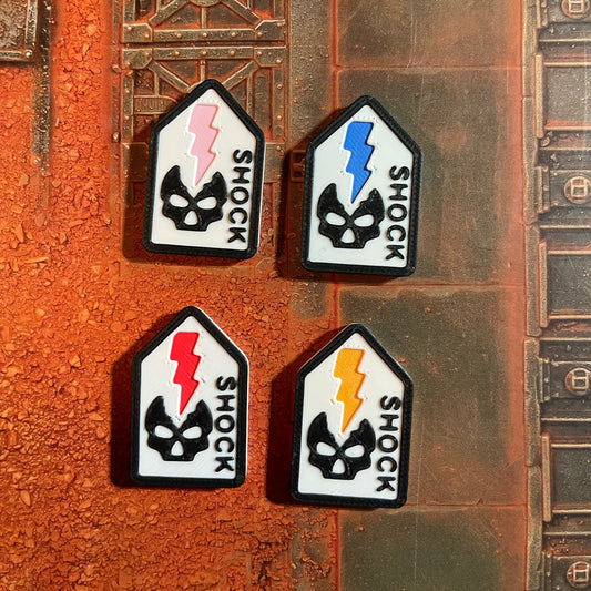 ttr-327-colours: the four accent colours side by side on Battle Shock tokens, Pink, Blue, Red and Orange