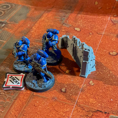 ttr-327-in-play-sticky: a Sticky Objective token on the table beside a squad of miniatures