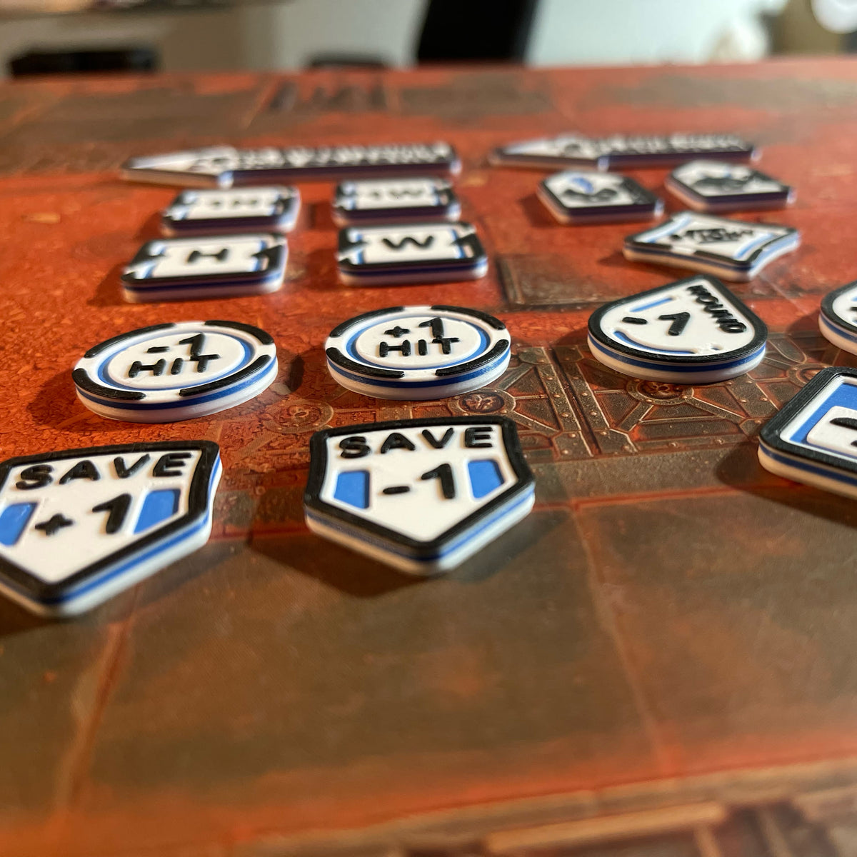 ttr-327-detail-print: low angle on Save and To Hit tokens, showing the three-colour printed lettering